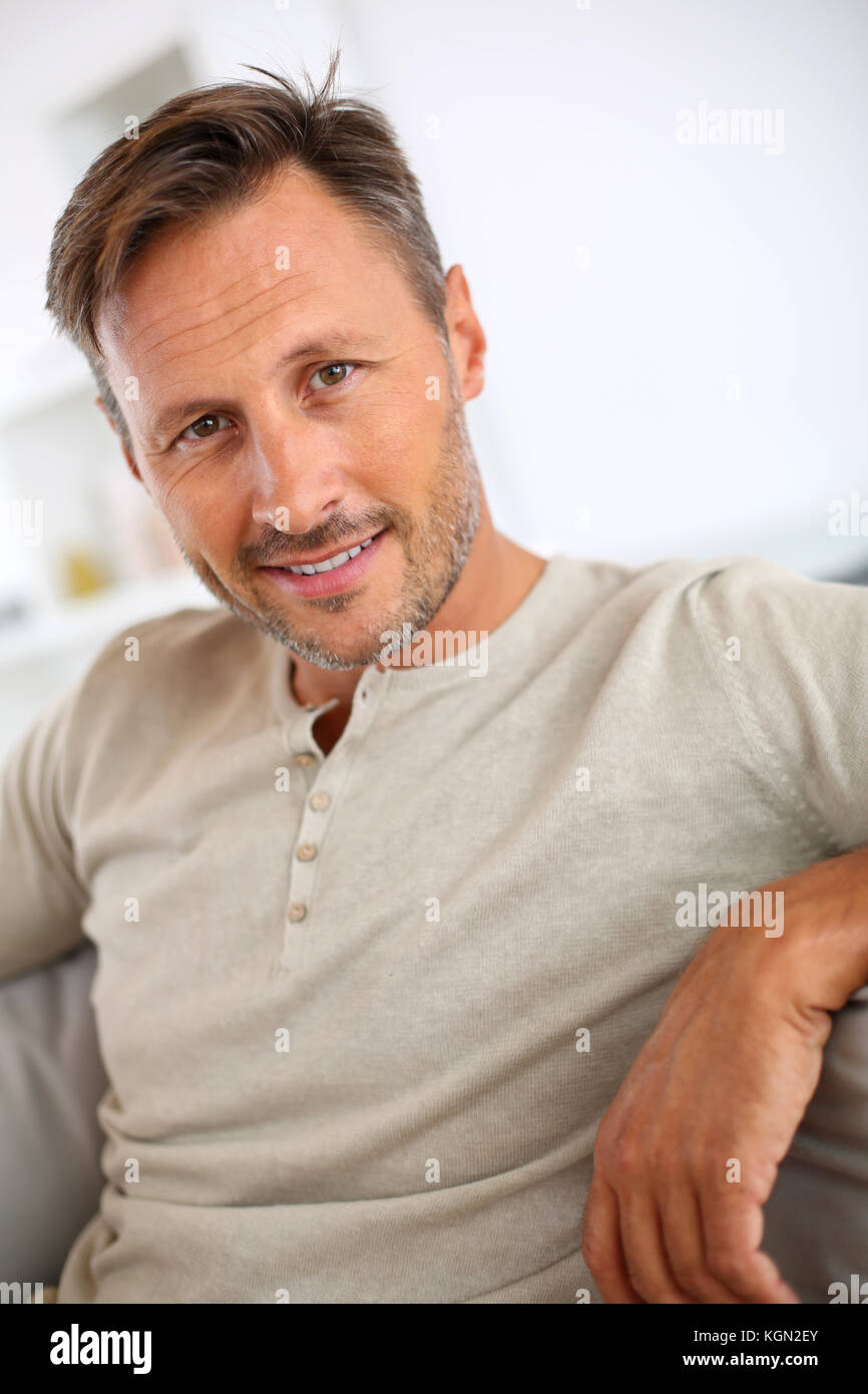 Bel homme de 40 ans dans le canapé relaxant Banque D'Images
