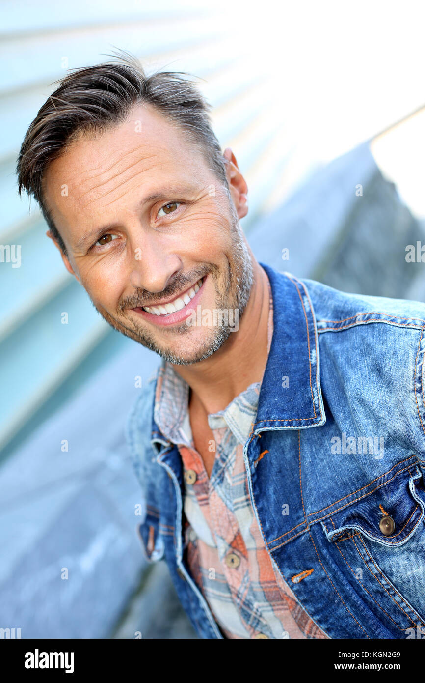 Smiling man standing by bâtiment moderne en ville Banque D'Images