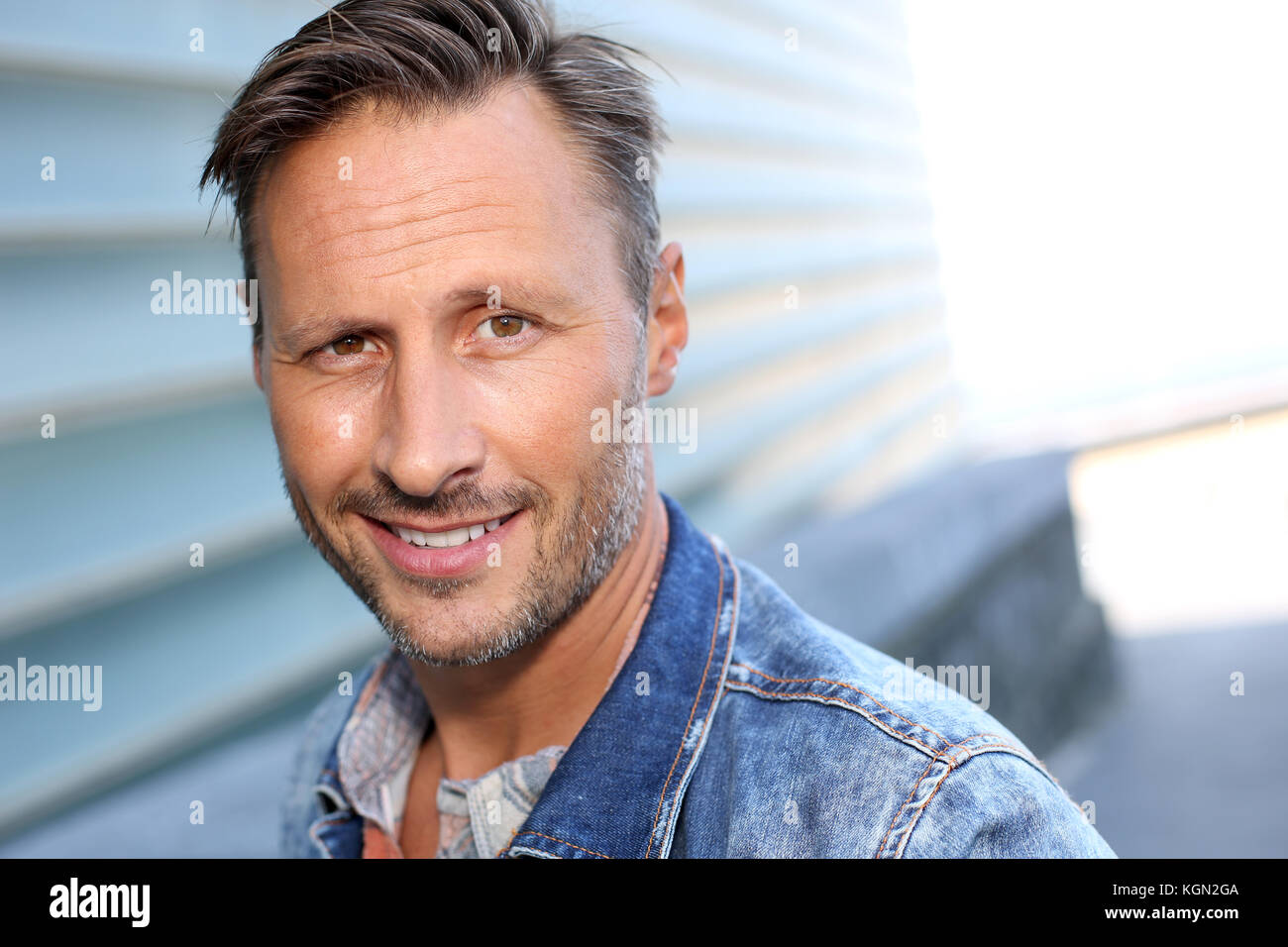 Smiling man standing by bâtiment moderne en ville Banque D'Images