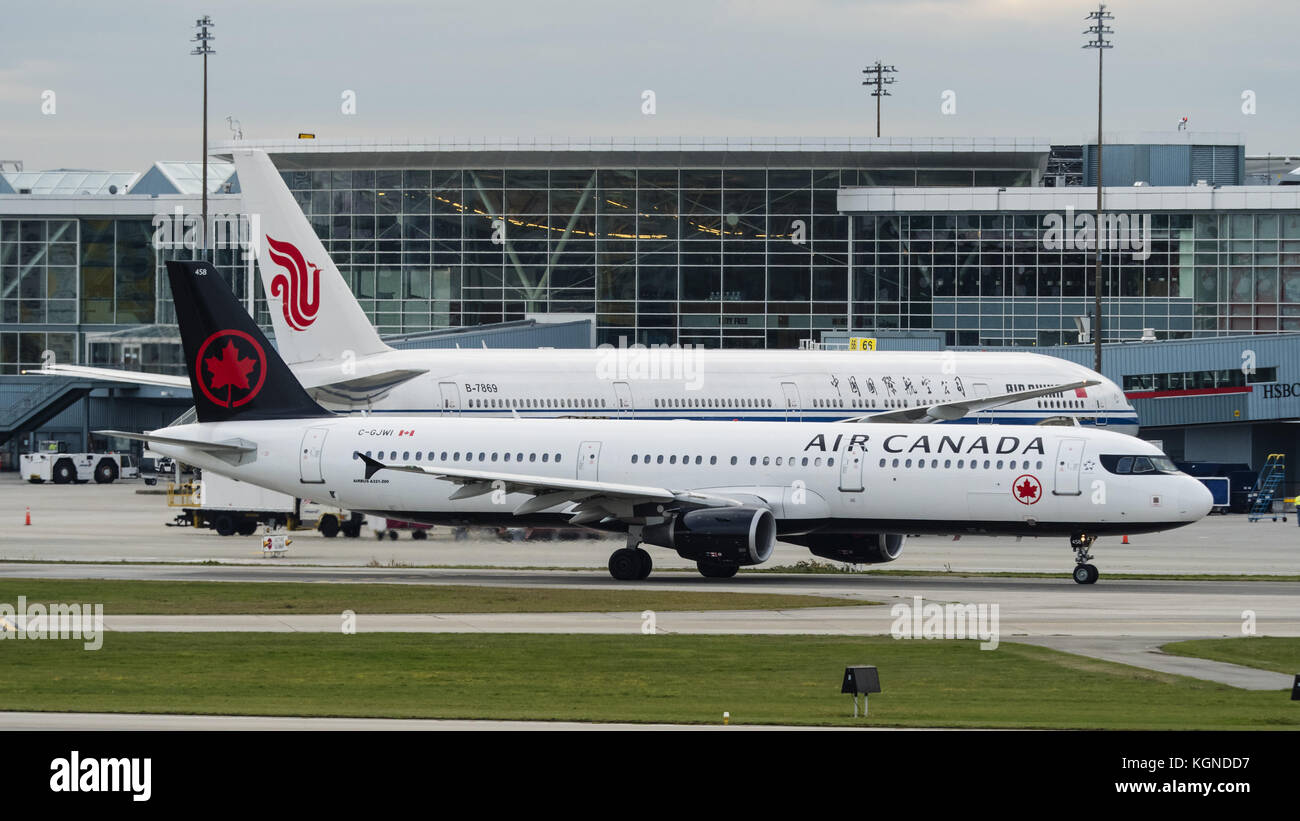 3 novembre 2017 - Richmond, Colombie-Britannique, Canada - un Airbus A321-200 d'air canada (c-gjwi à couloir unique) à fuselage étroit, avion de ligne circule au-delà d'un large-corps air china boeing 777 (b-7869) fixé à une porte de départ/arrivée au terminal international, l'aéroport international de Vancouver. (Crédit image : © bayne stanley via zuma sur le fil) Banque D'Images