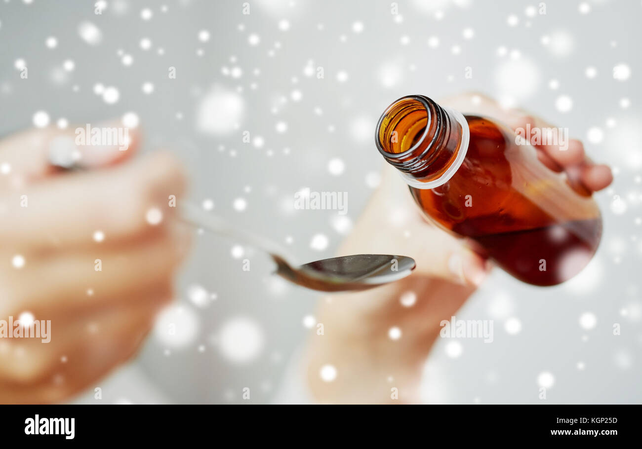 Woman pouring médicament du biberon à la cuillère Banque D'Images