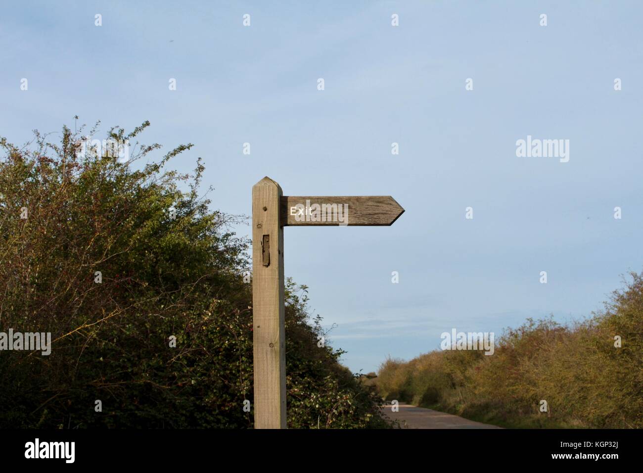 Sortie en bois blanc sur la flèche sur le post en bois en pays lane à l'horizontale, dirigée à droite dans le ciel vide Banque D'Images