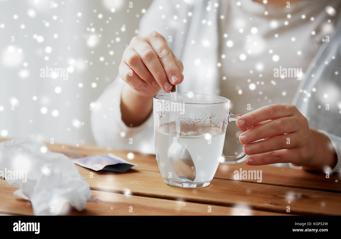 Femme malade en remuant de médicament en tasse avec cuillère Banque D'Images
