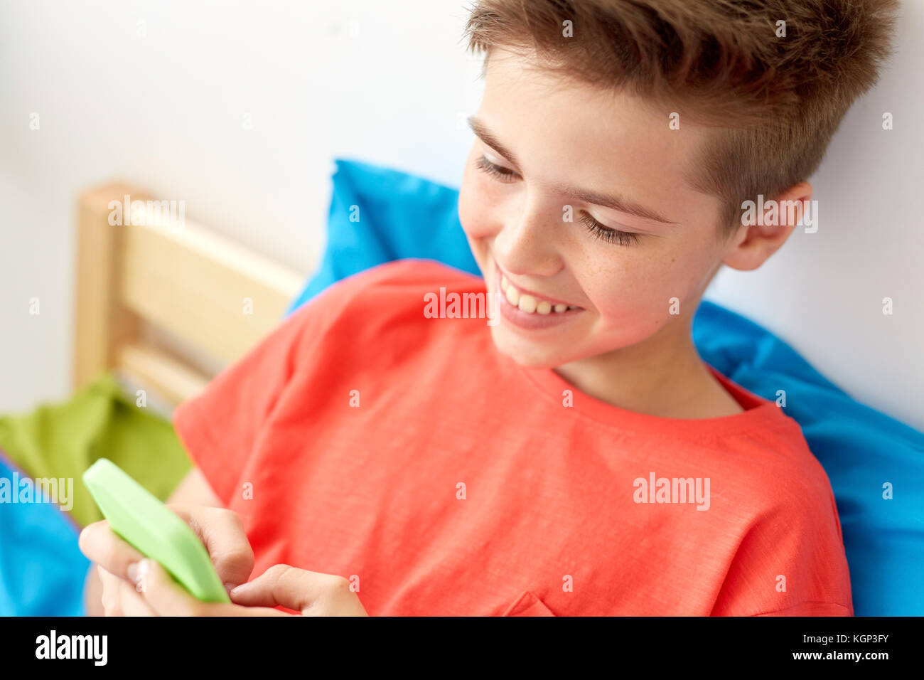 Close up of happy boy avec le smartphone à la maison Banque D'Images