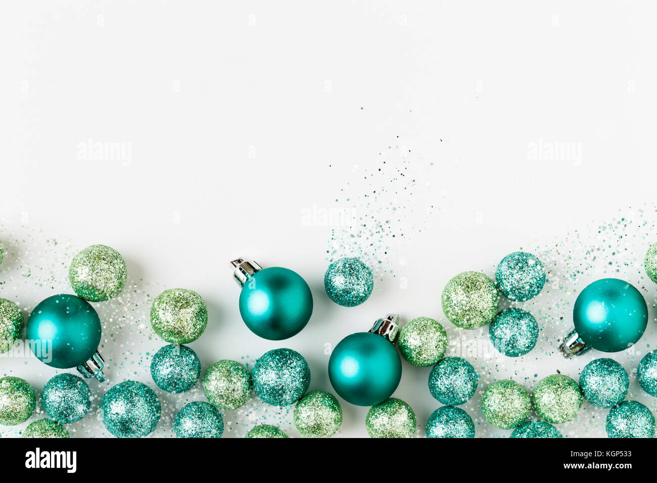 Beau, lumineux, moderne, bleu et vert décorations ornements de Noël avec paillettes scintillantes sur fond blanc. Frontière horizontale. Banque D'Images