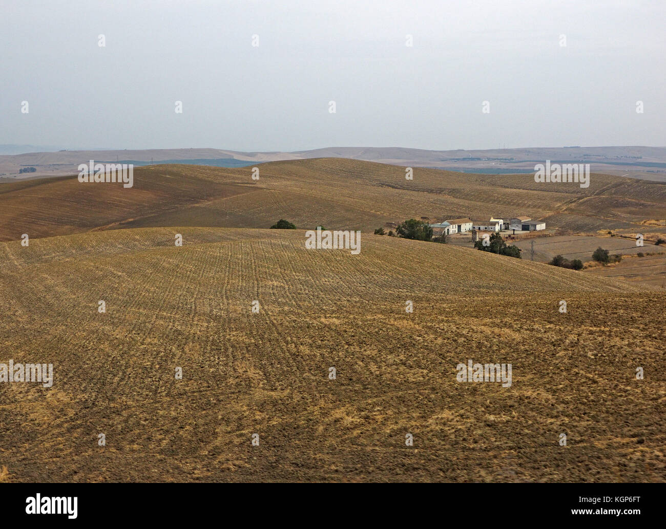 Ville Espagnole près de Cordoba avec des bâtiments blancs typiques niché derrière les collines arides en terres arables d'or paysage aride Banque D'Images
