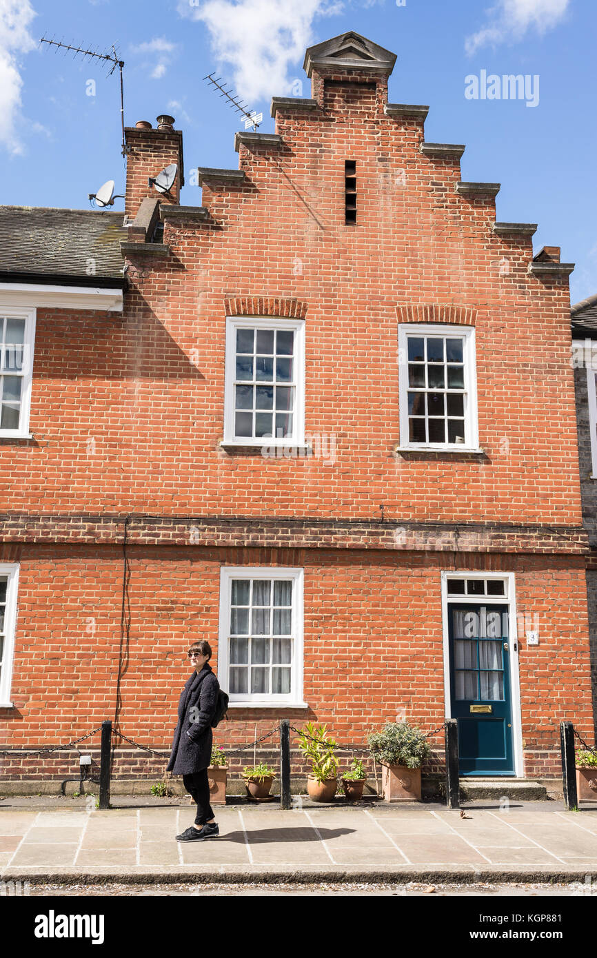 Hipster femme debout sur le trottoir en face d'une maison victorienne restaurée edwardian House à London, UK Banque D'Images