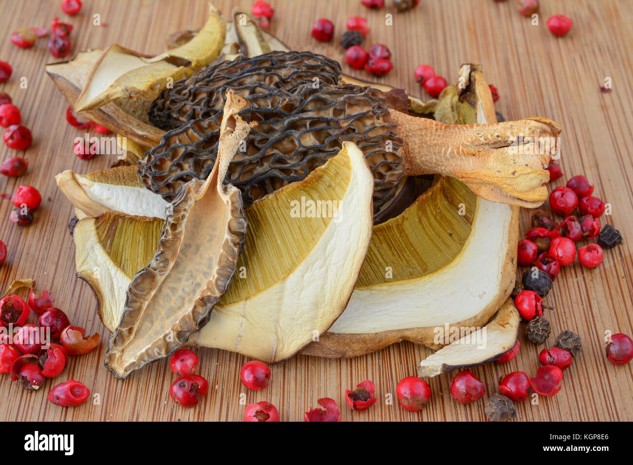 La qualité de première classe séché mixte cep et morilles sur fond de bois de bambou sombre, avec beaucoup de grains de poivre rouge Banque D'Images