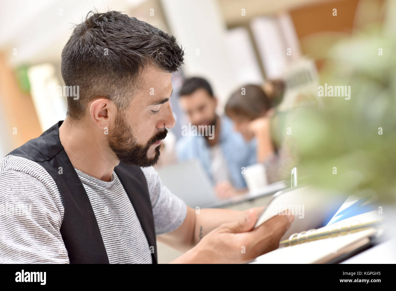 Trendy businessman in office travaillant sur tablet Banque D'Images