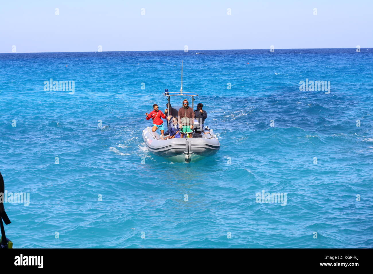 Un petit bateau gonflable Vigilanza sur l'eau de mer bleue en Sardaigne, Italie Banque D'Images
