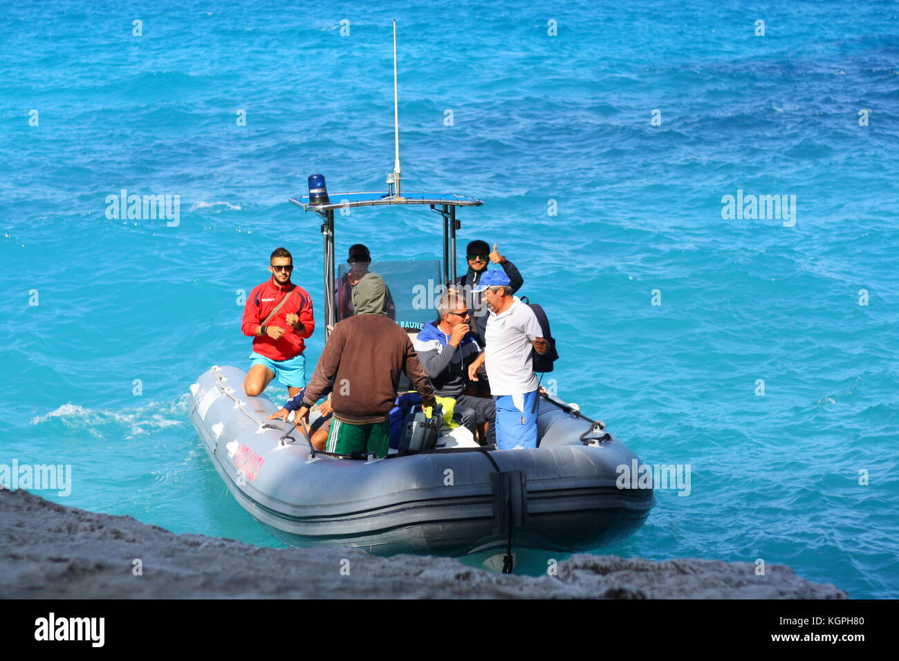 Un petit bateau gonflable vigilanza sur bleu de l'eau de mer en Sardaigne, Italie Banque D'Images