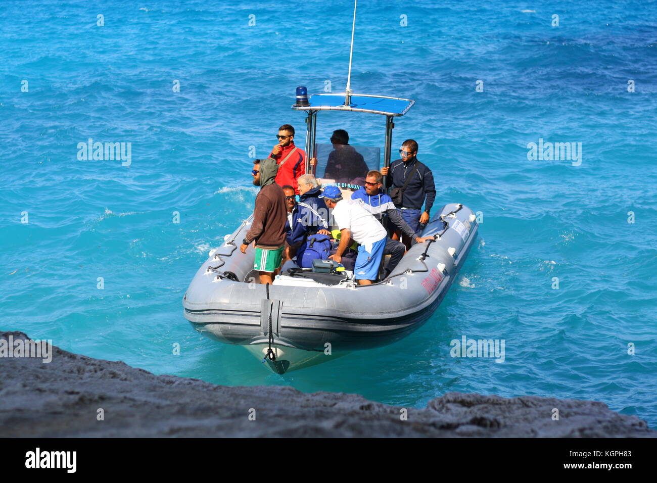 Un petit bateau gonflable Vigilanza sur l'eau de mer bleue en Sardaigne, Italie Banque D'Images