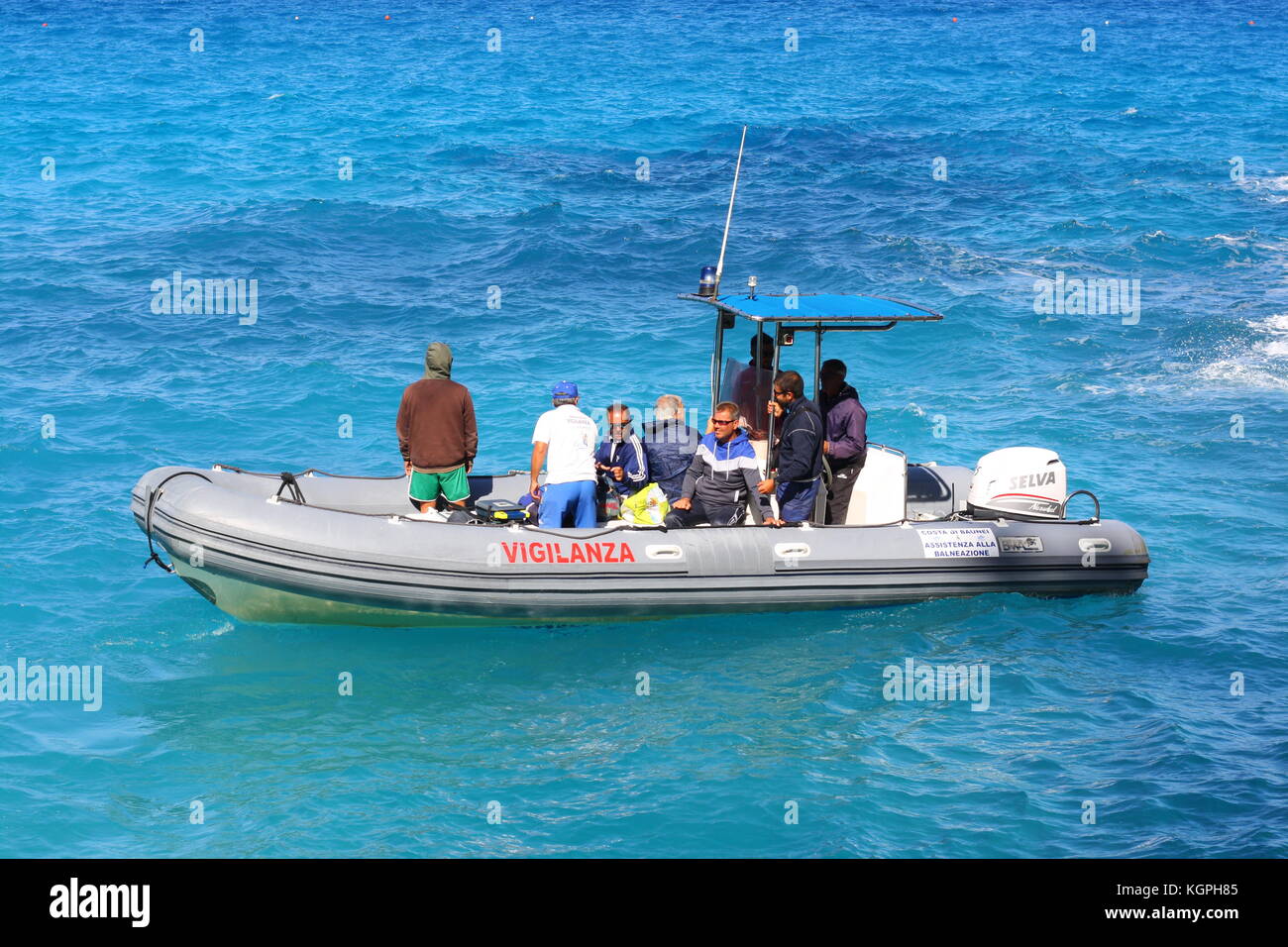 Un petit bateau gonflable Vigilanza sur l'eau de mer bleue en Sardaigne, Italie Banque D'Images