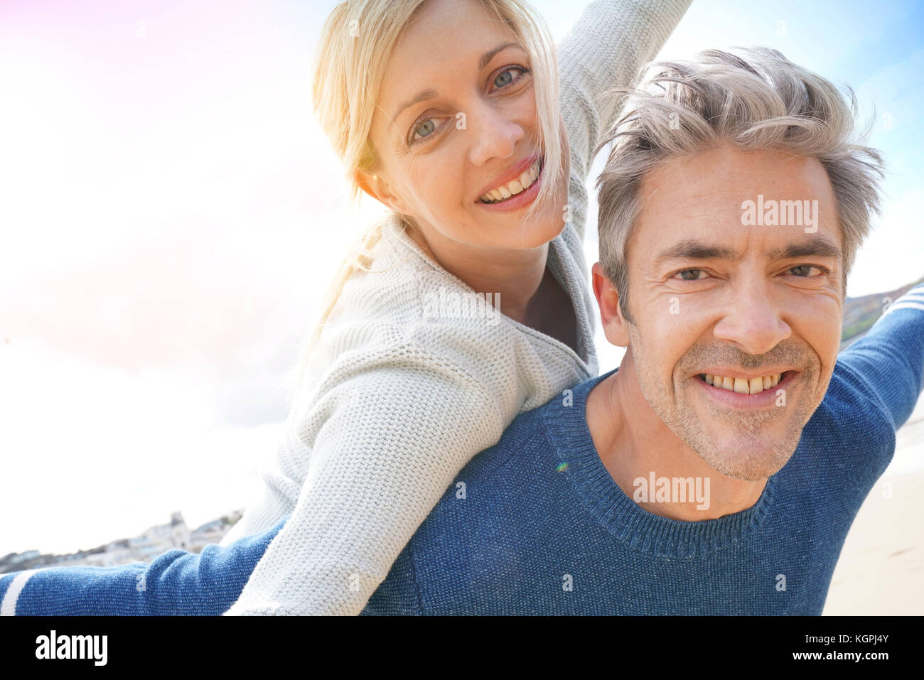 Man giving piggyback ride to woman at the beach Banque D'Images