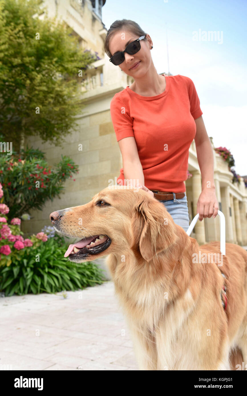 Femme Aveugle de flatter son chien-guide Banque D'Images