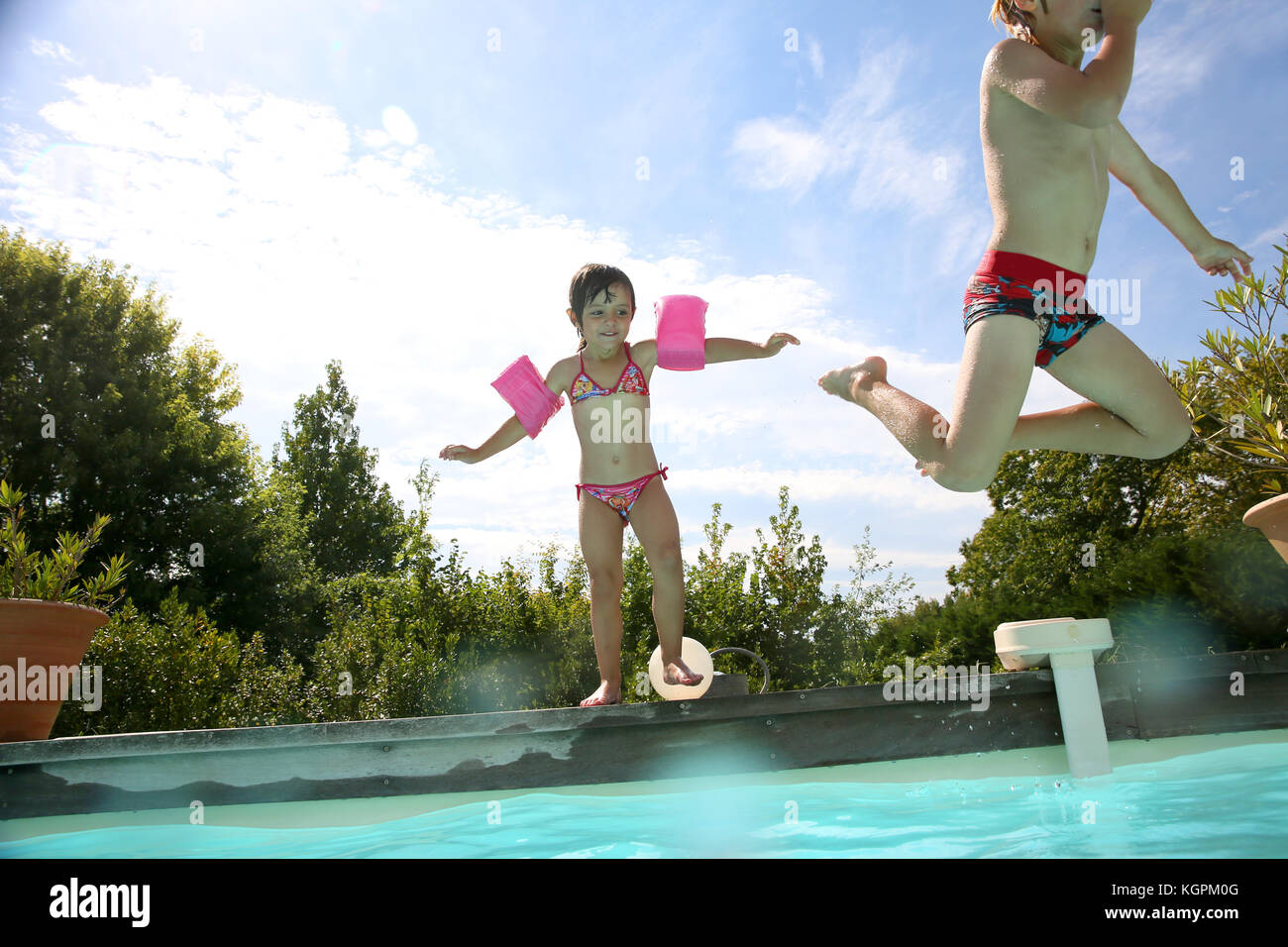 Enfants Sautant Dans La Piscine Banque d