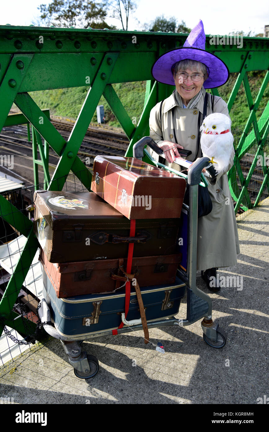 Femme âgée sur le pont de kings cross (utilisé dans le film de Harry Potter) à ropley, Hampshire posant comme un personnage de Poudlard pendant un assistant Banque D'Images