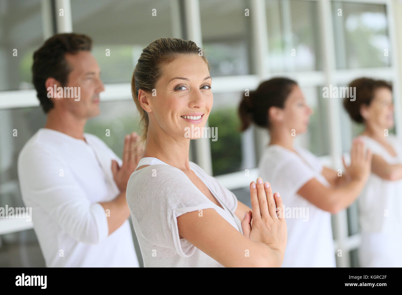 Attractive blonde femme participant à des cours de yoga avec group Banque D'Images