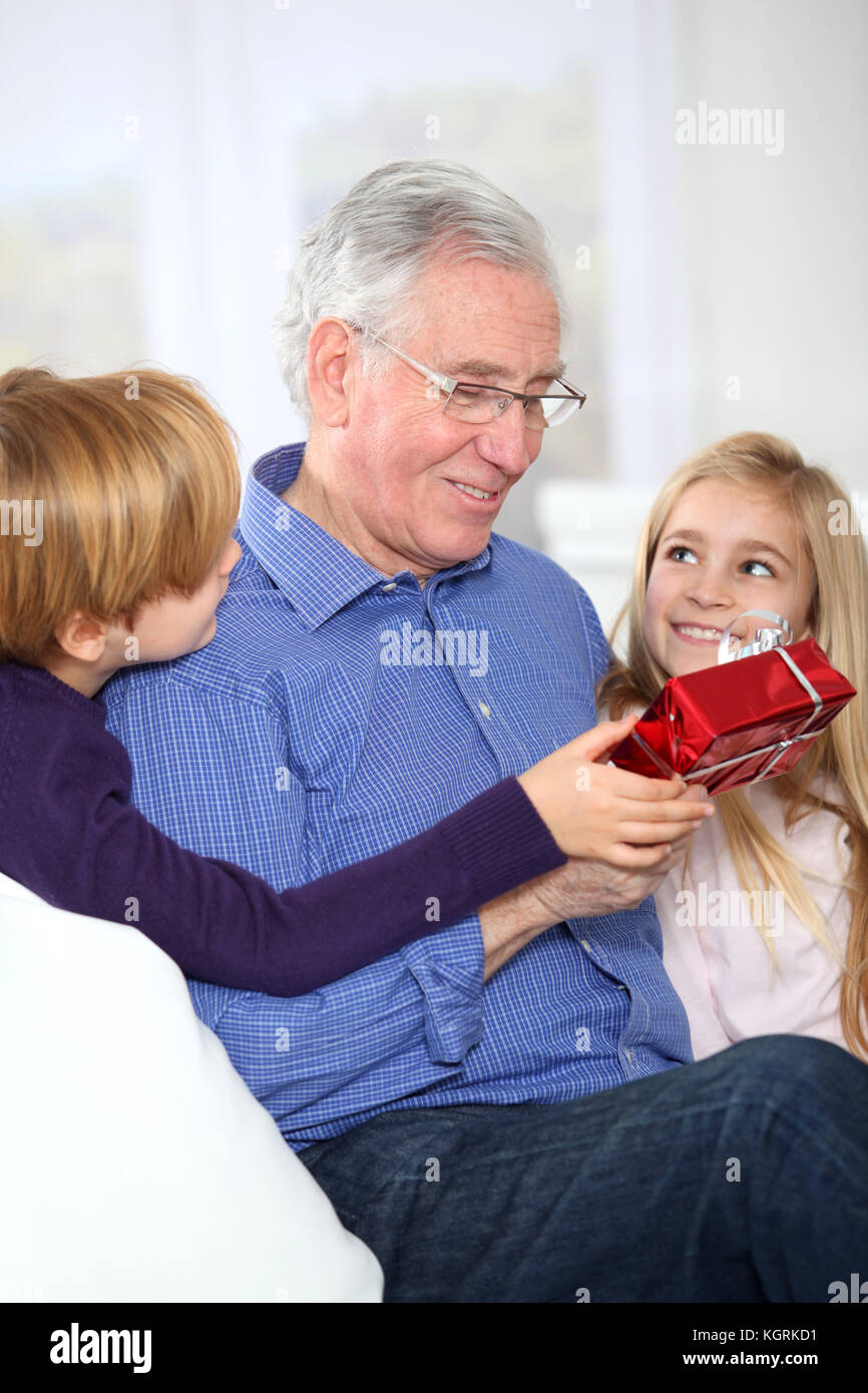 Les Enfants De Donner Le Cadeau D Anniversaire De Leur Grand Pere Photo Stock Alamy