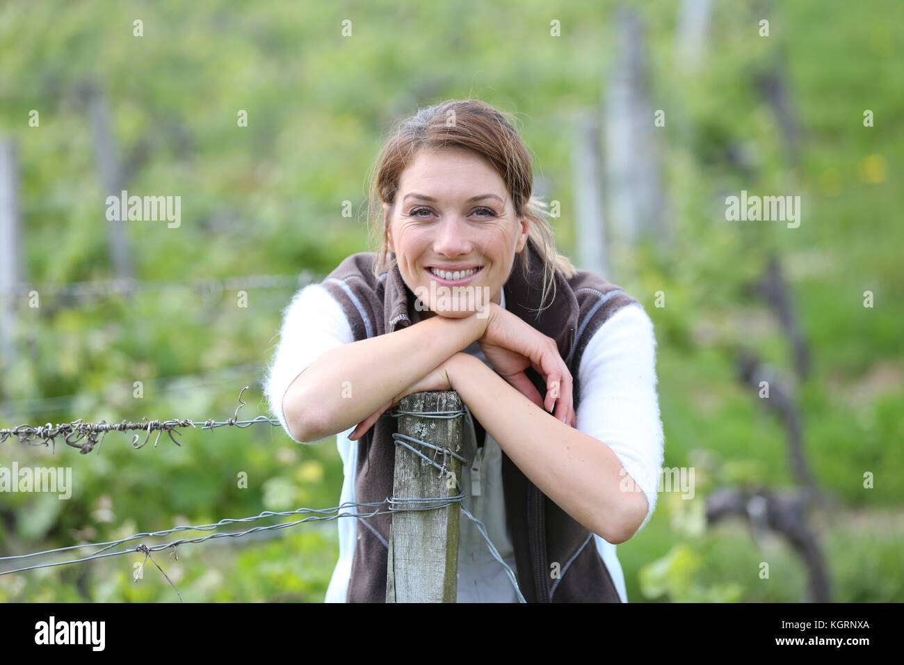 L'agriculture smiling woman standing in vineyard Banque D'Images