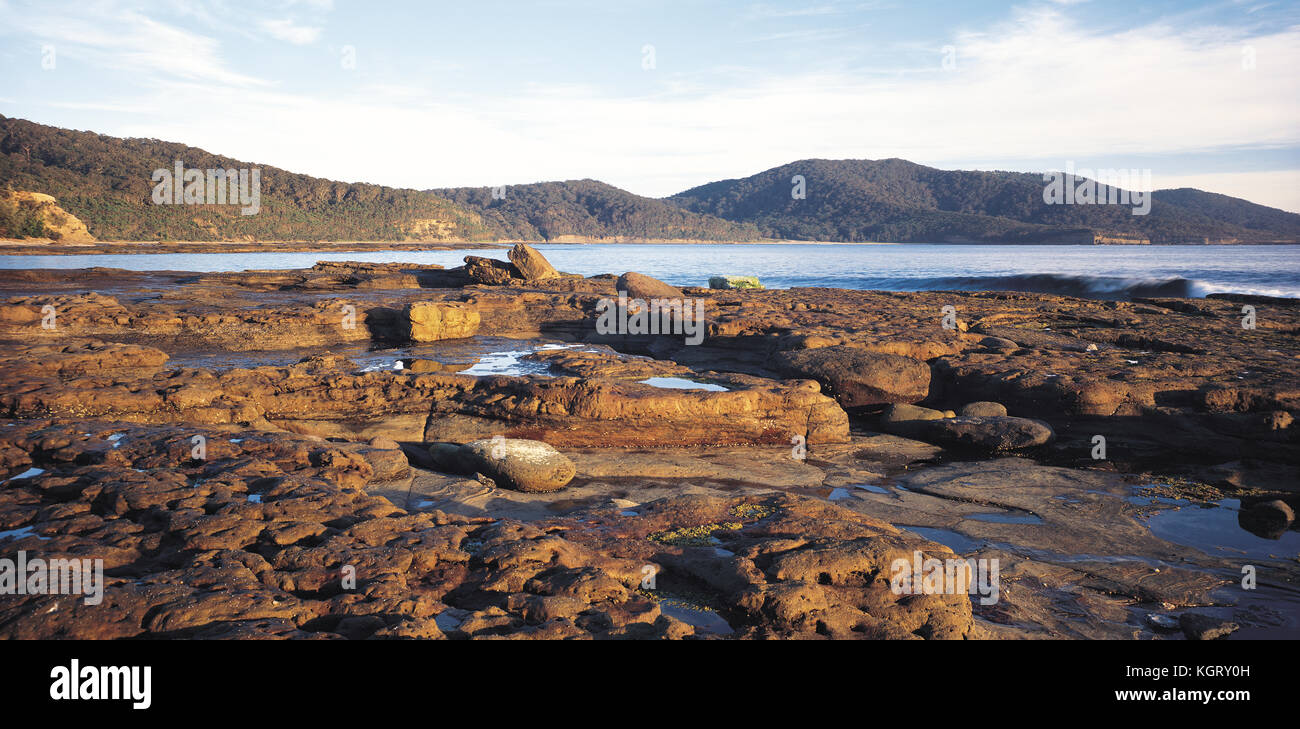 La montagne de Durras Depot Beach sur la plate-forme de roche, Murramarang National Park, New South Wales, Australie Banque D'Images