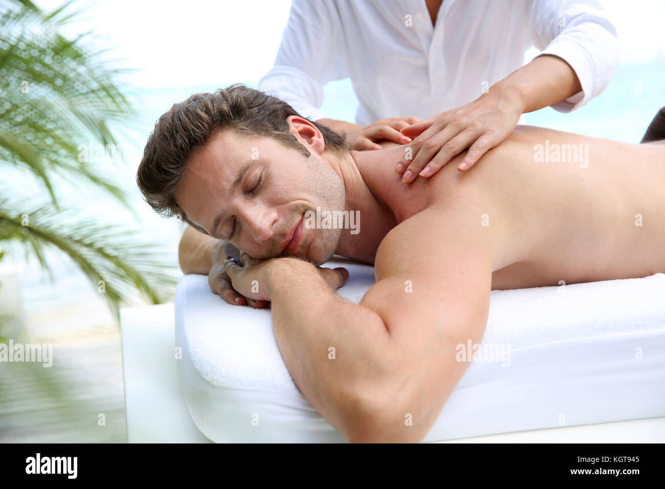 Bel homme allongé sur un lit de massage Banque D'Images
