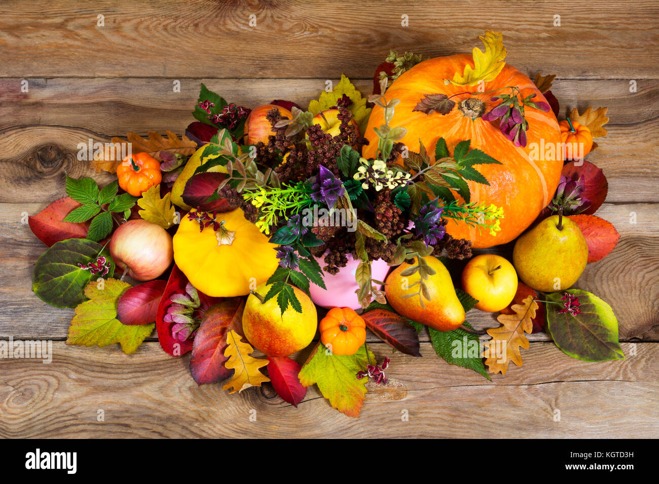 De grâce ou à l'automne avec des fleurs sauvages dans le vase rose, citrouilles, pommes, poires et colorés de l'automne laisse sur le fond de bois, haut vi Banque D'Images