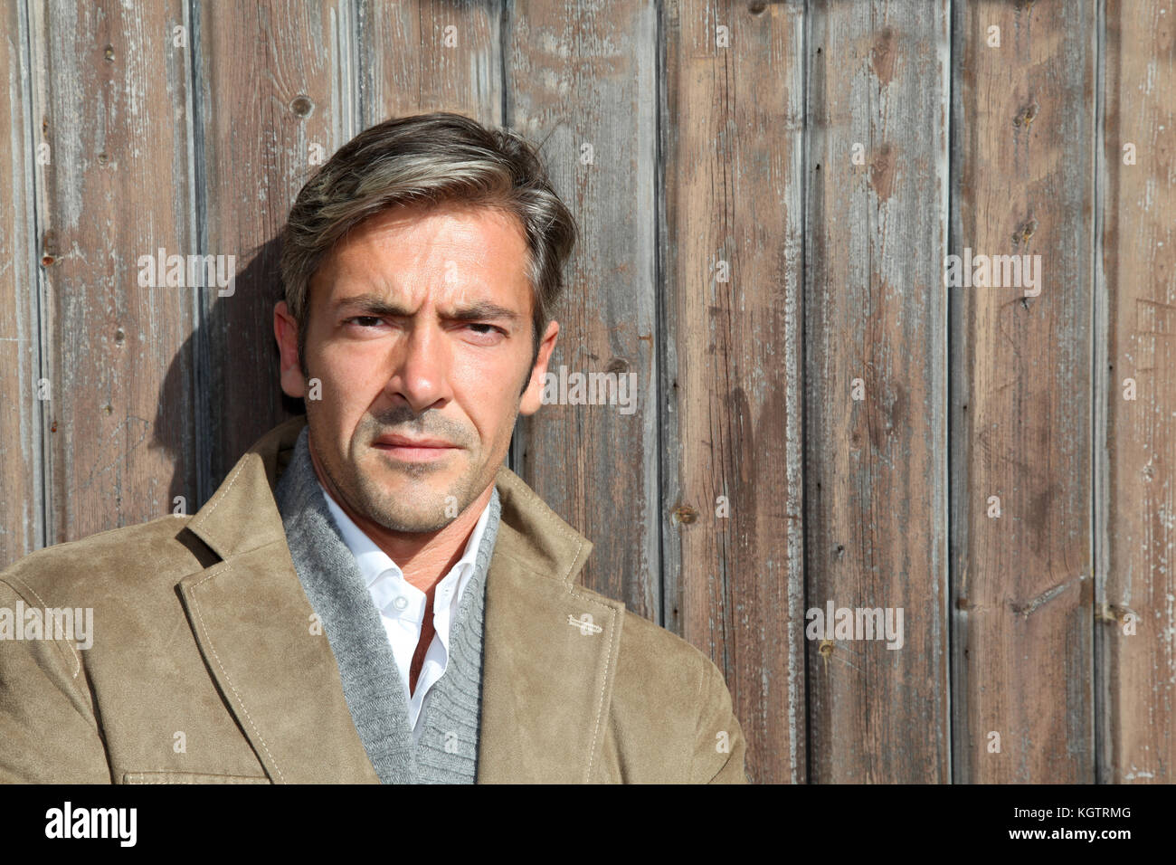 Handsome guy standing contre maison en bois Banque D'Images