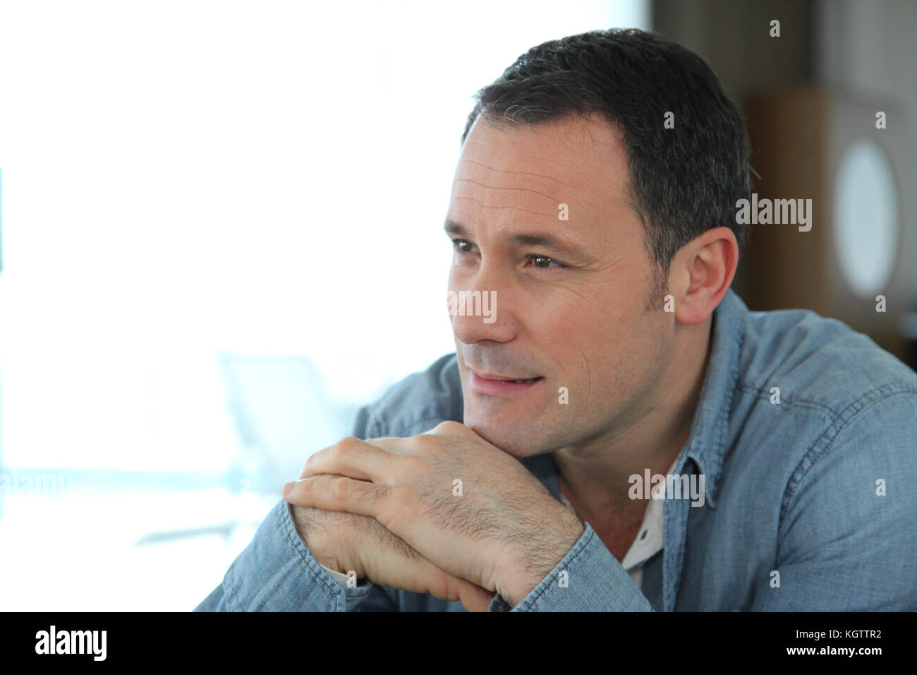 Portrait de l'homme assis dans la salle de séjour Banque D'Images