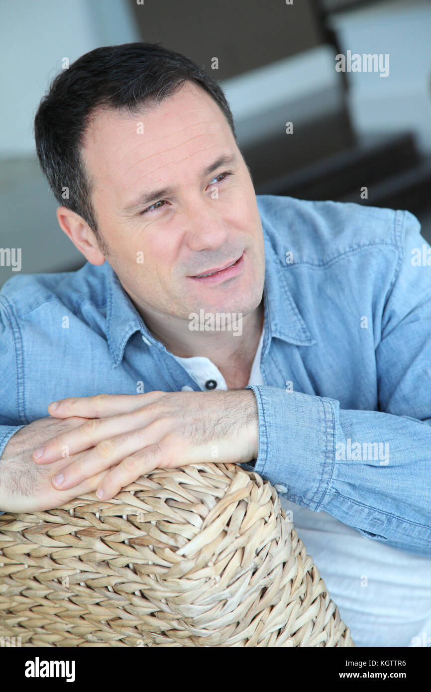 Portrait de l'homme assis dans la salle de séjour Banque D'Images