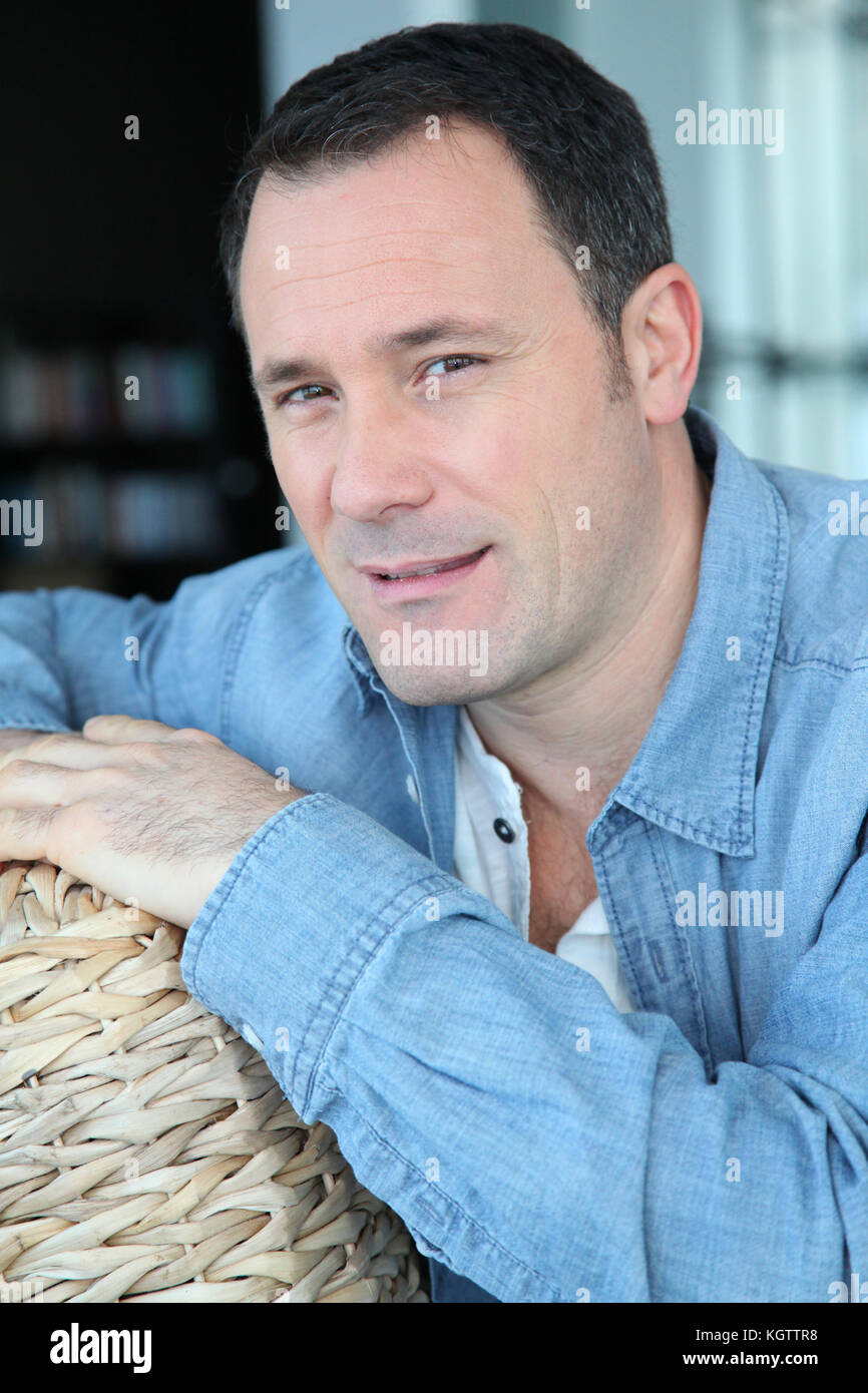 Portrait de l'homme assis dans la salle de séjour Banque D'Images