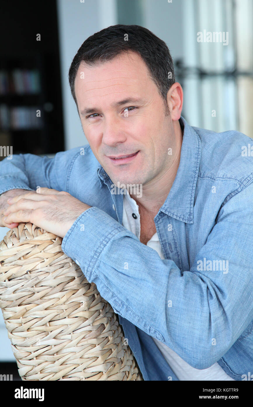 Portrait de l'homme assis dans la salle de séjour Banque D'Images