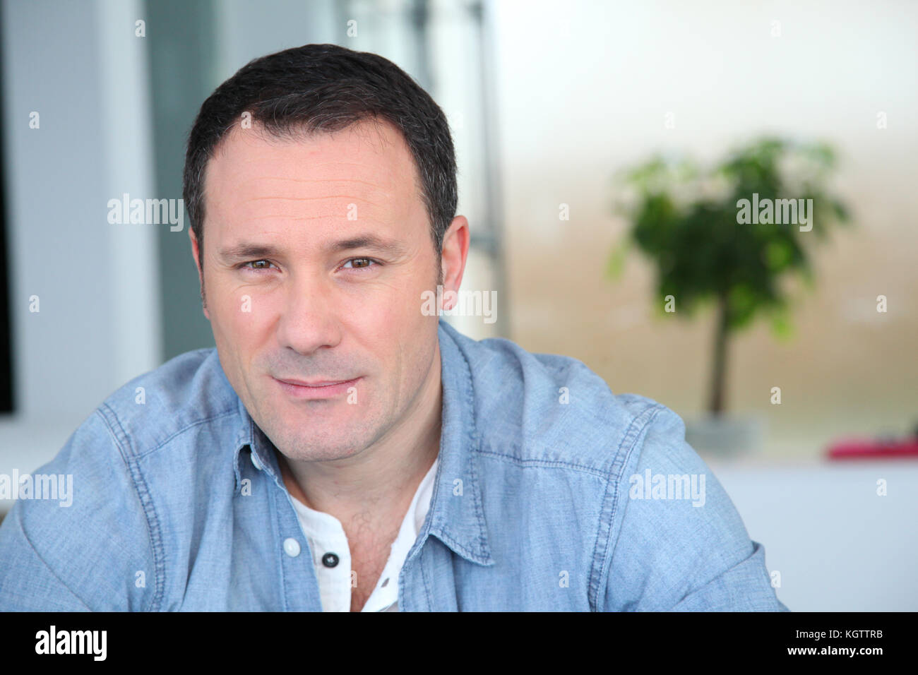 Portrait de l'homme assis dans la salle de séjour Banque D'Images