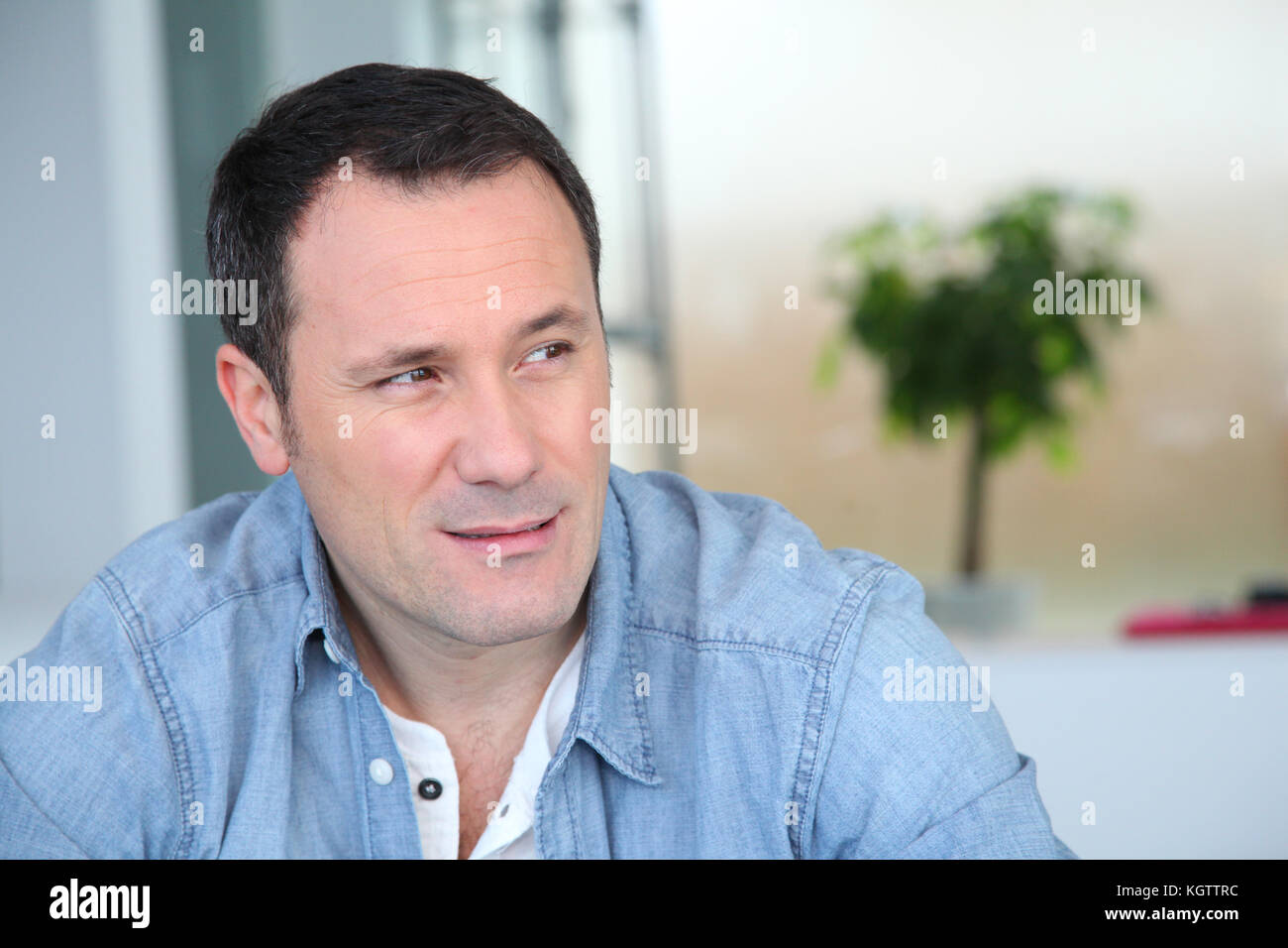 Portrait de l'homme assis dans la salle de séjour Banque D'Images