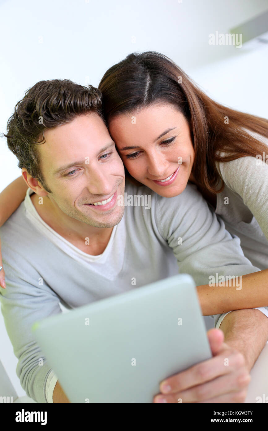 Ferra cheerful couple sur internet avec tablet Banque D'Images