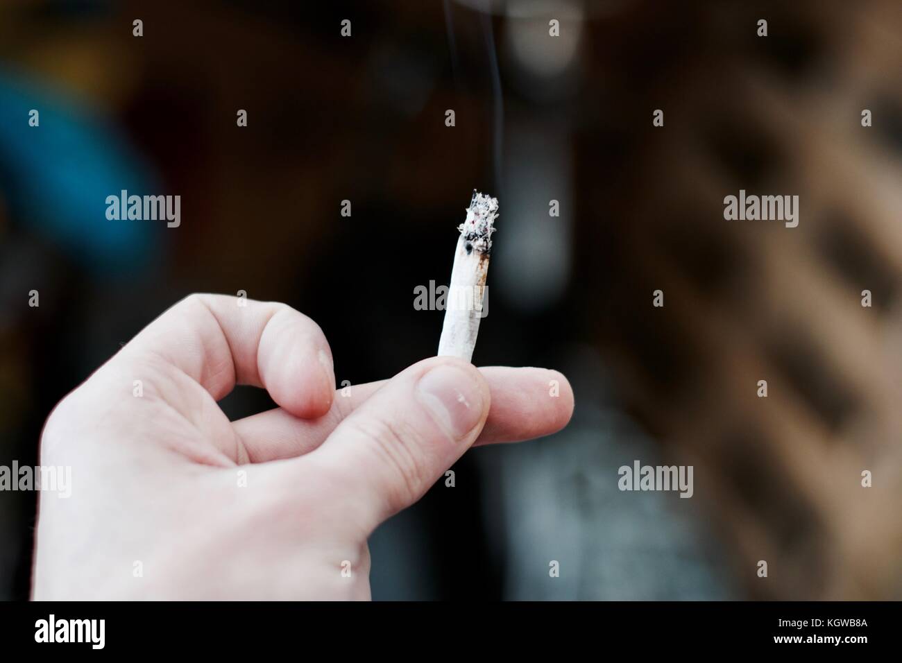 Petit spliff dans l'homme de main. concept fumer de la marijuana. Banque D'Images