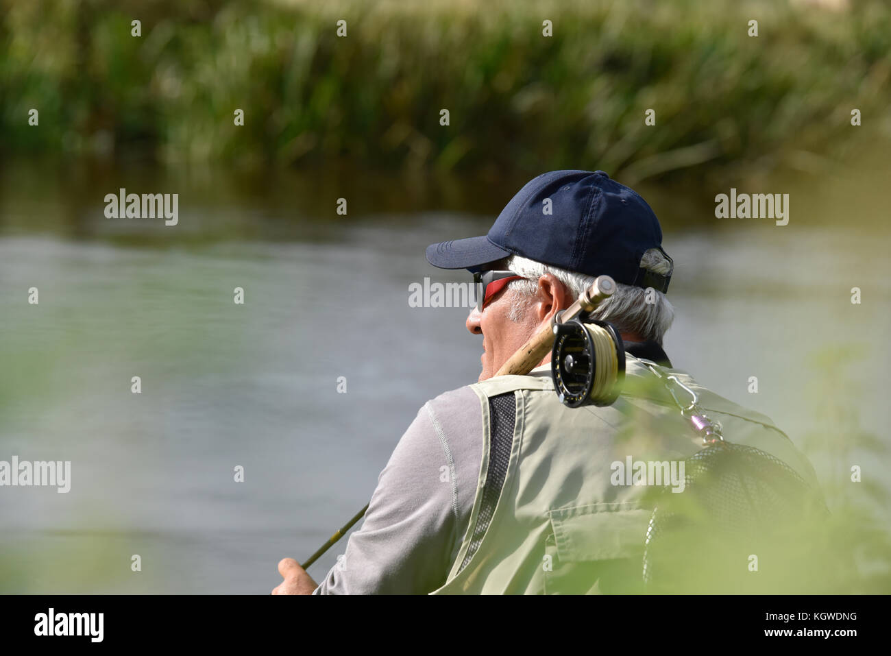 Pêcheur à la mouche en attente avec canne à pêche sur l'épaule Banque D'Images