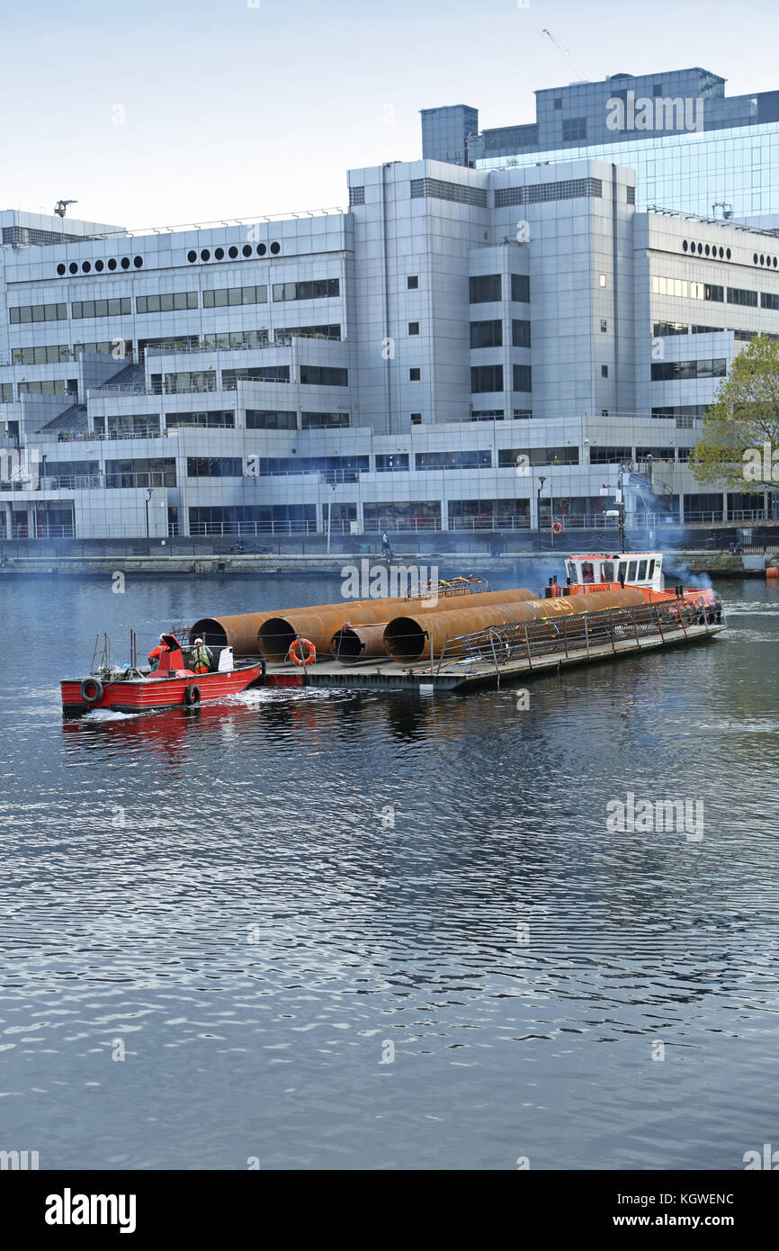 Des carters de pieux en acier de grand diamètre sont livrés à un chantier de construction de Canary Wharf par barge éliminant le besoin de transport routier. Manœuvre Banque D'Images