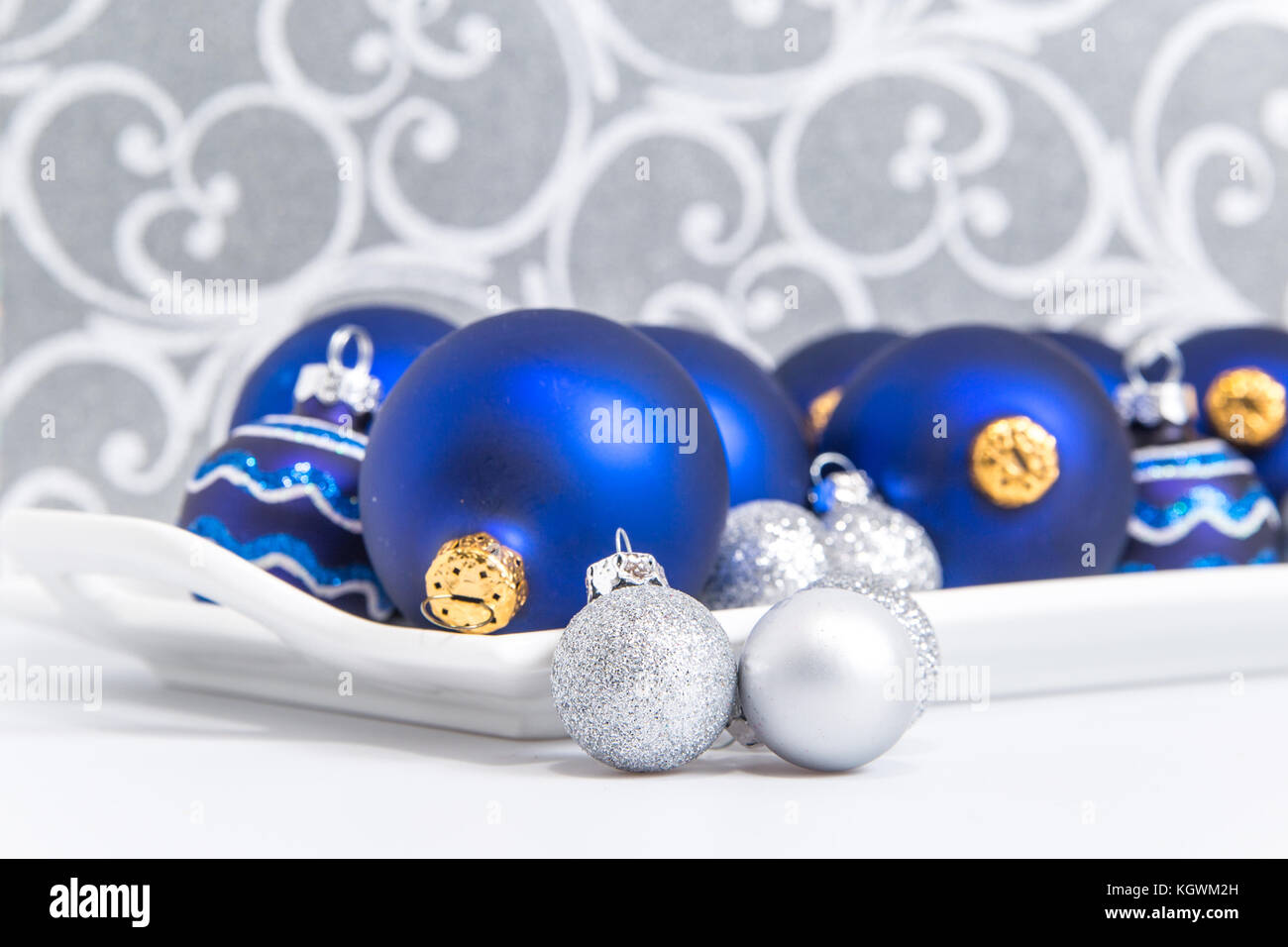 Bleu et argent boules de noël sur un plateau avec des tourbillons d'argent en arrière-plan Banque D'Images