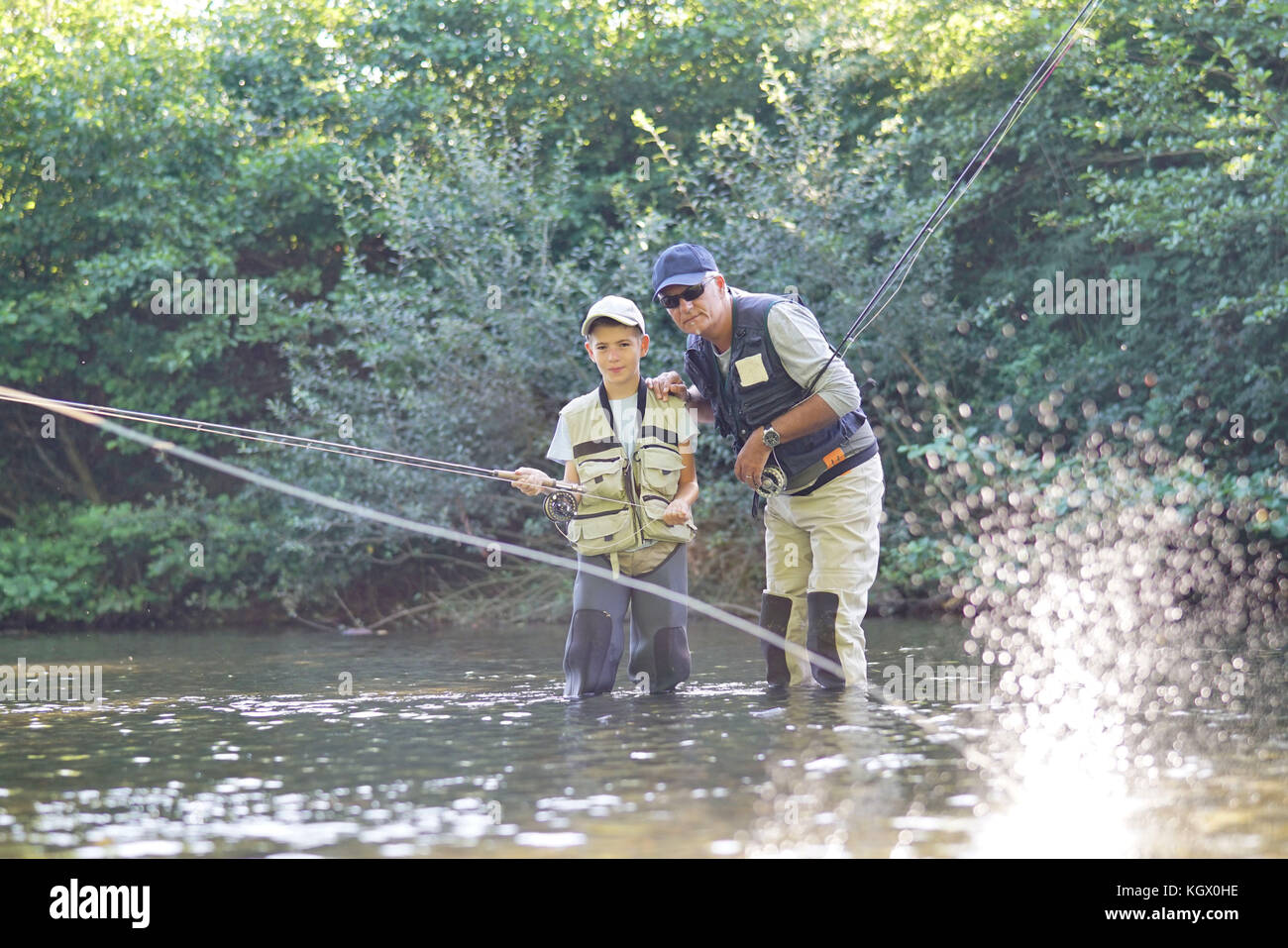 L'enseignement du père fils comment voler-pêche en rivière Banque D'Images