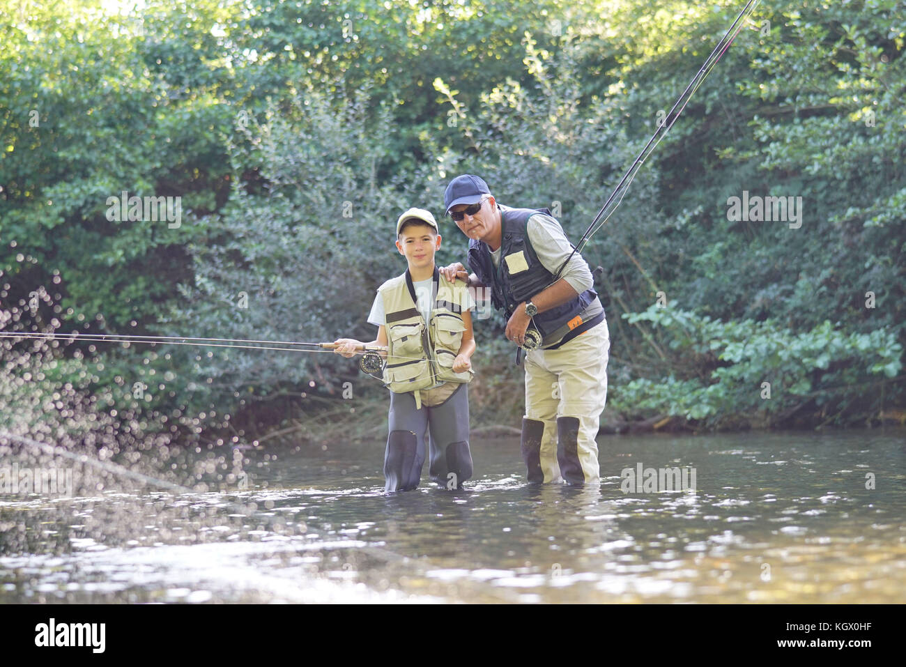 L'enseignement du père fils comment voler-pêche en rivière Banque D'Images