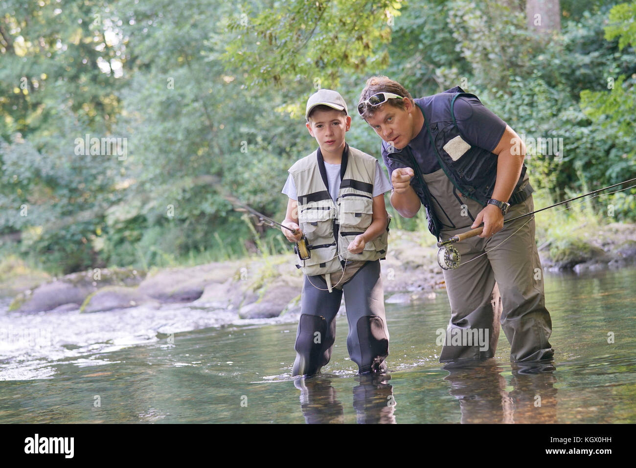 L'enseignement du père fils comment voler-pêche en rivière Banque D'Images