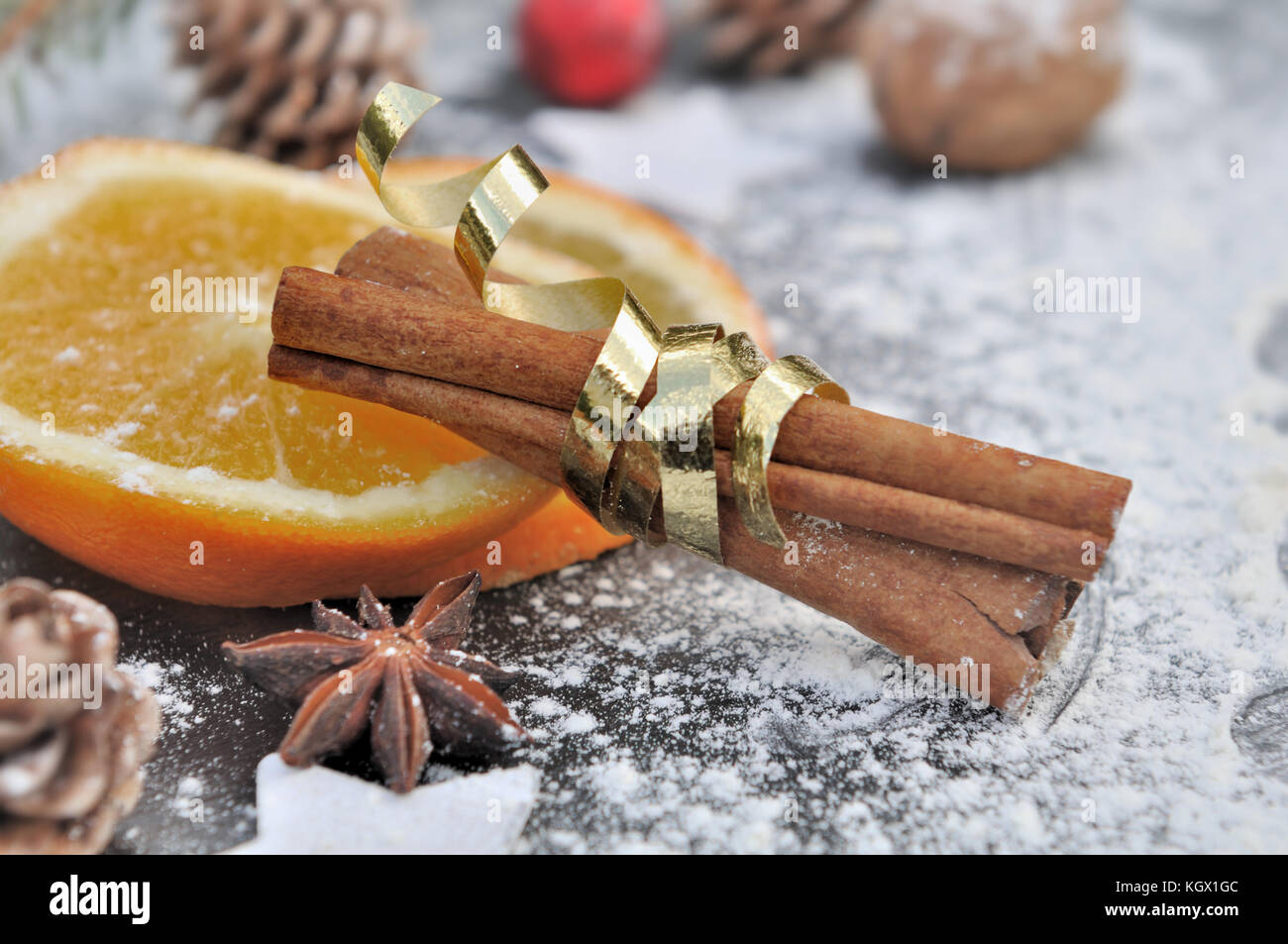 Bâton de cannelle en ruban doré sur tranche d'orange Banque D'Images