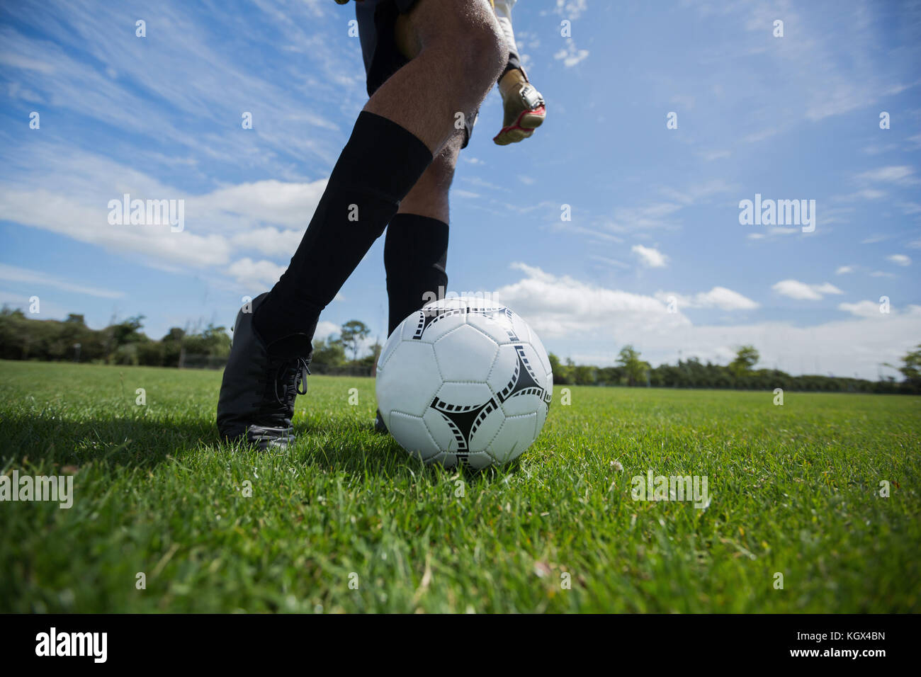 Gardien de but prêt à kick le ballon de soccer dans le sol Banque D'Images