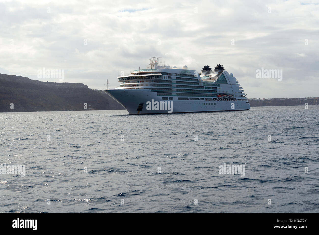 Bateau de croisière au large de Santorin sur un jour nuageux. Banque D'Images