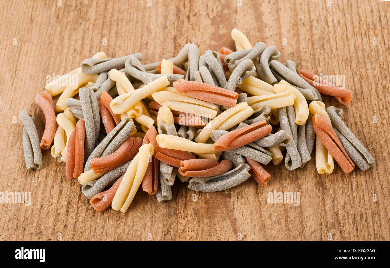 Les pâtes italiennes strozzapreti colorés sur fond de bois Banque D'Images