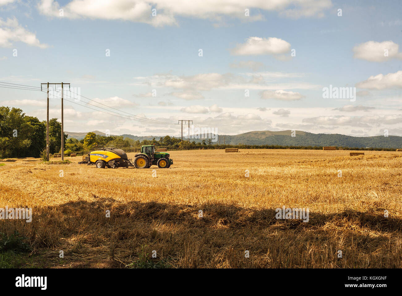 Foin du tracteur en face de puisage le malvern hills, Worcestershire Banque D'Images