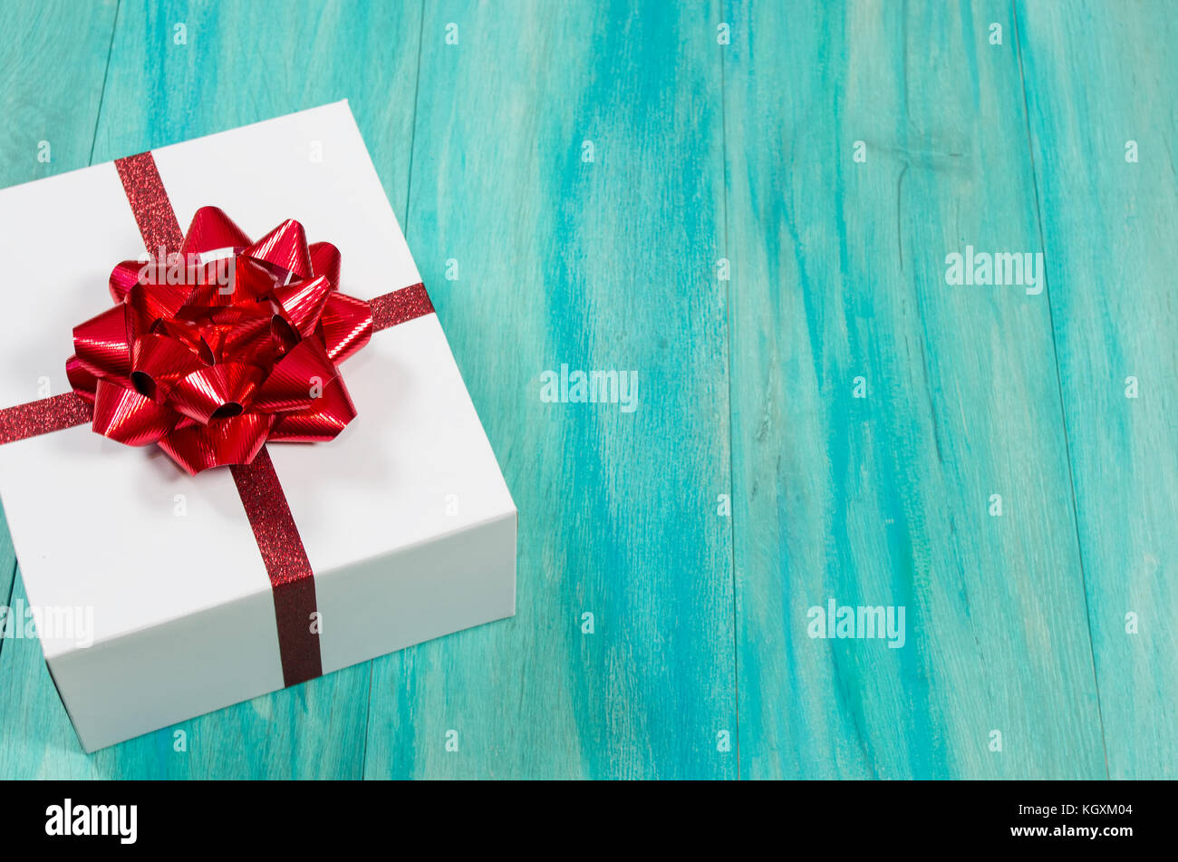 Cadeau de Noël unique offset avec arc rouge sur un fond de bois sarcelle en détresse Banque D'Images
