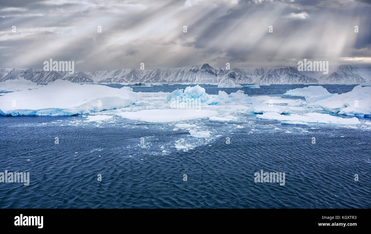 Avis de Snow Hill Island, l'Antarctique, de la mer, avec des icebergs et de la glace bleue au premier plan. Beaux rayons du soleil tombant sur les collines enneigées. Banque D'Images