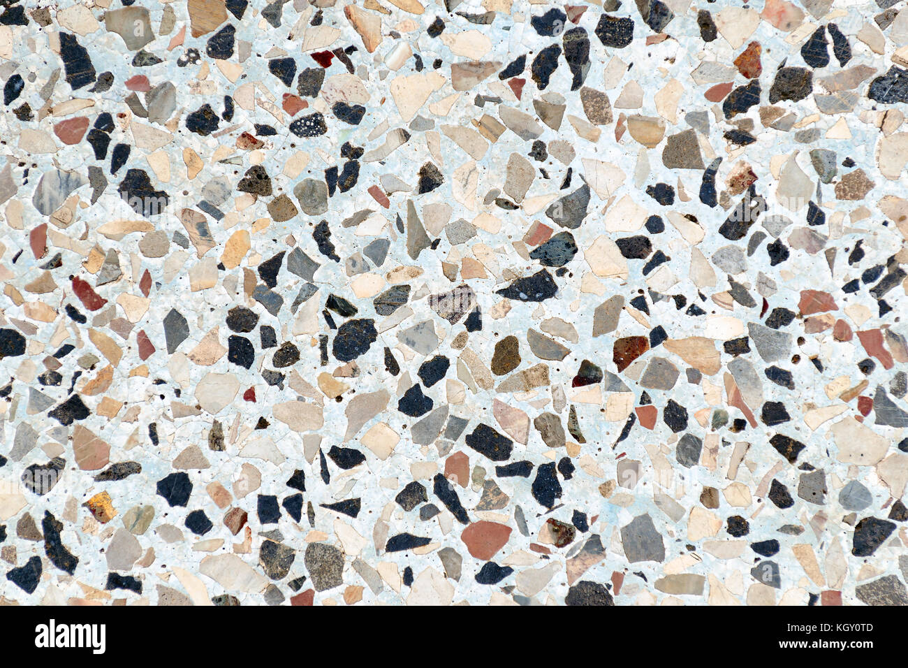 Multi-couleur de petites pierres plates sont immergés dans le béton. abstract background. Banque D'Images